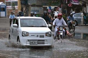 Vehicles are passing through rain water accumulated on road during the rain in the Provincial Capital.