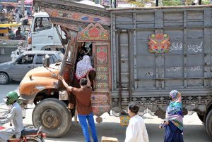 A couple and their children arrive at Pirwadai Bus Stand to depart for their hometown, where they will celebrate the upcoming Eid-ul-Azha with their family