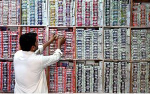 A shopkeeper matches thread colors at his shop near Resham Gali.
