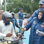Traffic staff installing side mirrors on motorcycles during an awareness campaign at Cherang Cross.