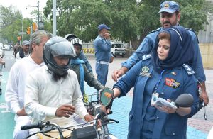 Traffic staff installing side mirrors on motorcycles during an awareness campaign at Cherang Cross.
