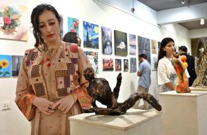 Visitors keenly viewing artwork by students during an exhibition organized under the Community Outreach Program at NCA.