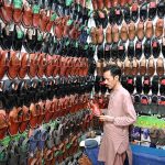 A person selecting traditional shoes from shop at Reshamgali for preparation of upcoming Eidul Adha