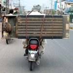 A Person on the way loaded with a refrigerator on the rear seat of a Motorcycle at LMQ road.