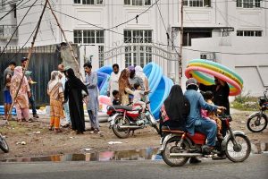 Families purchase inflatable swimming pools from roadside stalls for their children to bathe and cool off in the summer heat.