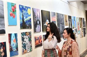 Visitors keenly viewing artwork by students during an exhibition organized under the Community Outreach Program at NCA.