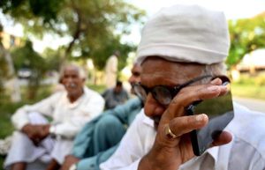 An elder man listening the 2025-26 federal budget live on his mobile phone at a roadside in the Federal Capital