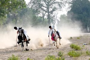 Horse riders of Omani Bike Busher Club exhibiting their skills during their visit to Tehsil Bhalwal.