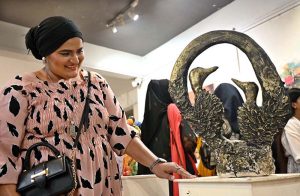 Visitors keenly viewing artwork by students during an exhibition organized under the Community Outreach Program at NCA.
