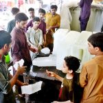 People purchase ice from a vendor at Bacha Khan Chowk to beat the summer heat.