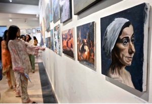 Visitors keenly viewing artwork by students during an exhibition organized under the Community Outreach Program at NCA.