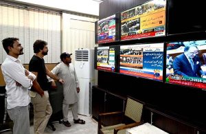 Citizens watching the 2025-26 federal budget live on television screens
