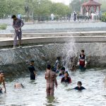 Youngsters enjoy bathing during hot weather in the city.