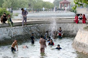 Youngsters enjoy bathing during hot weather in the city.