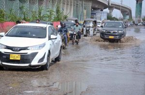 Vehicles wade through rainwater accumulated on Qayyumabad Road after heavy rainfall in Provincial Capital.
