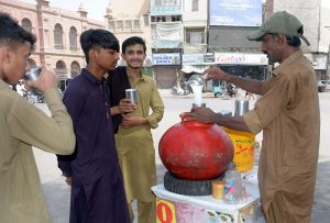 A vendor selling a traditional summer drink (Lassi) during the hot weather in the city