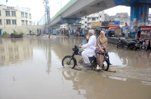 Motorcyclist passing through rainwater accumulated on the Korangi crossing after rain that experienced in the city.