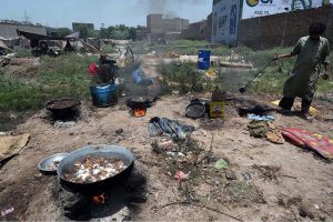 Gypsy person boiling meat after collecting on Eid ul Adha at Ring road