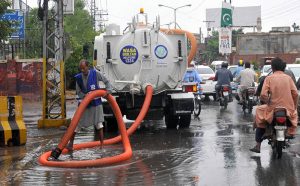 female commuter rides an electric scooter through heavy rain as the monsoon spell hits the city.
