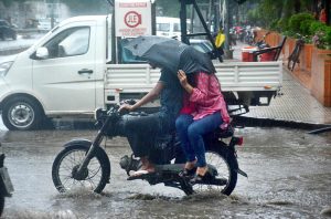 Motorcyclist passing through rainwater accumulated on the Korangi crossing after rain that experienced in the city.