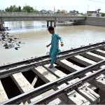 A youngster crossing the railway bridge near Nazar Muhalla