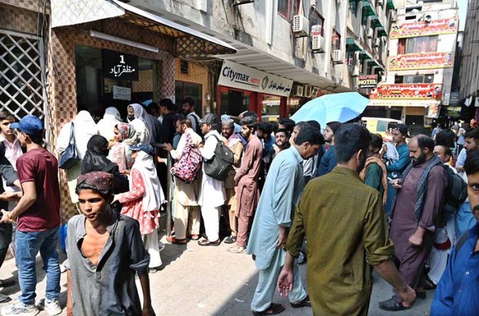 A large number of people standing in queue to purchase bus tickets at Faizabad Bus Stop to depart for their hometowns to celebrate Eidul Adha with their relatives.