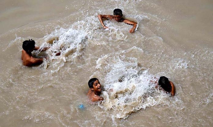 Youngsters bathing in Rice Canal to get some relief from scorching hot weather in the city