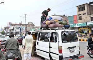 People carrying their luggage board a van at Noori Gate as they travel to their hometowns to celebrate Eid-ul-Azha.
