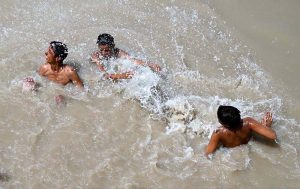 Youngsters bathing in Rice Canal to get some relief from scorching hot weather in the city