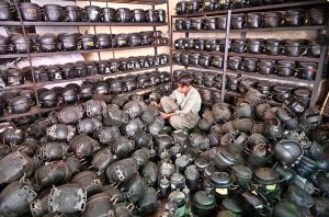 A young technician busy in arranging air conditioner unit compressors at his workshop during hot summer day in City.
