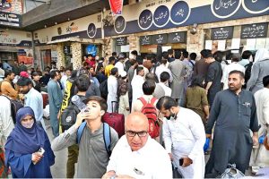 A large number of people standing in queue to purchase bus tickets at Faizabad Bus Stop to depart for their hometowns to celebrate Eidul Adha with their relatives.