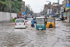 Vehicles navigate through a rain-flooded road, highlighting the challenges faced by commuters during heavy monsoon showers in the city.