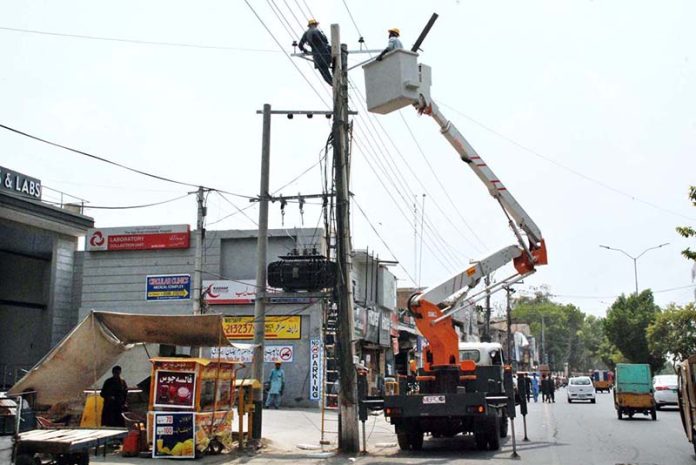 WAPDA workers remove damaged wires and install new ones during maintenance work