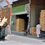 Labourers off-loading bags of fertilizer from the delivery truck at Gala Mandi.