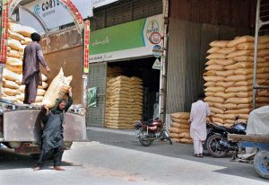 Labourers off-loading bags of fertilizer from the delivery truck at Gala Mandi.