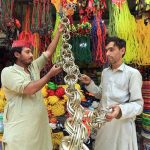 A vendor displays colorful decorative accessories for sacrificial animals to sell ahead of Eid-ul-Adha, attracting customers at the Ring Road area