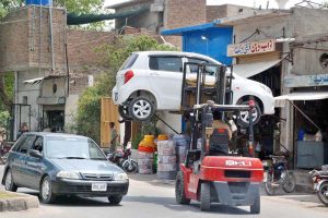 A traffic policeman uses a lifter to remove a wrongly parked vehicle obstructing the flow of traffic