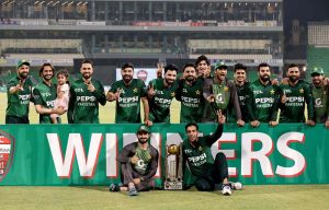 Pakistani players pose for a group photo with the winning trophy after clinching the T20 International three-match series against Bangladesh at Gaddafi Cricket Stadium.