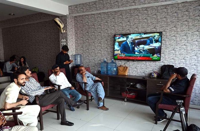 Citizens watching the 2025-26 federal budget live on television screen