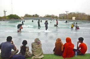 Children enjoy floating on tube boats in a water park pool to beat the heat on a hot summer day.