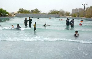 Children enjoy floating on tube boats in a water park pool to beat the heat on a hot summer day.