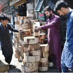 A shopkeeper displays and sells wooden molds for preparing meat ahead of Eid-ul-Adha outside his shop at Sodiwal