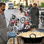 A vendor busy frying traditional food item Samosa near F-6 area in the Federal Capital