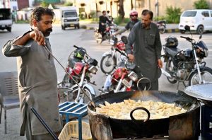 A vendor busy frying traditional food item Samosa near F-6 area in the Federal Capital