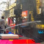 A firefighter extinguishes a fire that erupted in the Saddar Electronic Market