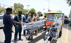 Police officials taking action against overloading, minors and unlicensed motorcycle and rickshaw drivers at Club Chowk during an awareness campaign of traffic rules