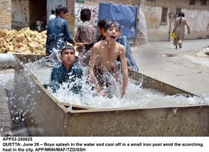 Boys cool off in a small iron pool amid the scorching heat in the city.