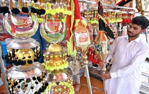 A vendor displaying Muharram procession related stuff to attract people.
