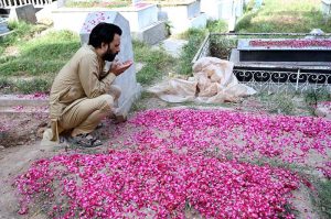 People offering Fateha on graves of their relatives in a local graveyard on the occasion of Eidul Azha