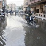 A motorcyclist wades through stagnant sewerage water at Pan Mandi area